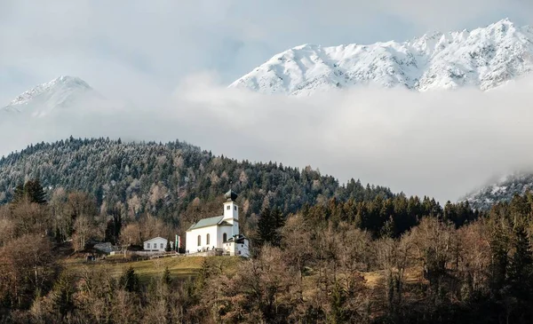 Edificio Bianco Sulle Colline Coperte Boschi Neve Sotto Cielo Nuvoloso — Foto Stock