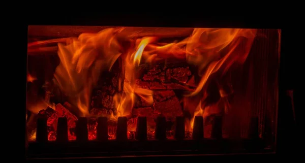 a closeup shot of burning wood in a fireplace