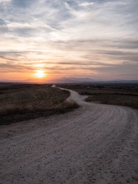 Vertikální Záběr Cestu Travnatém Poli Úchvatným Výhledem Západ Slunce Pozadí — Stock fotografie