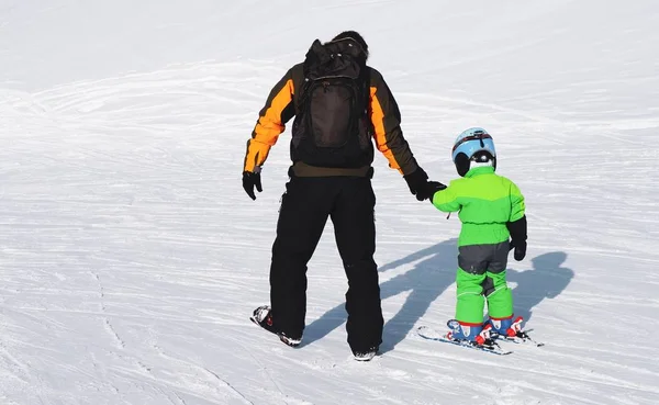 Padre che aiuta suo figlio a fare sci alpinismo durante il giorno — Foto Stock