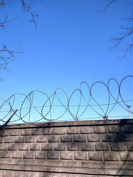 Cabo Metal Com Bordas Afiadas Uma Parede Feita Pedras Retangulares — Fotografia de Stock