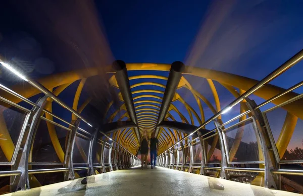 橋の上を夜間に歩く人々のタイムラプスショット — ストック写真