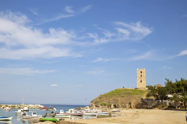 Piccolo porto con barche da pesca in una zona turistica, torre medievale, cielo blu con poche nuvole, estate , — Foto Stock