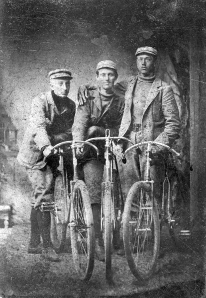 Vertical shot of three men with their vintage bicycles — Stock Photo, Image