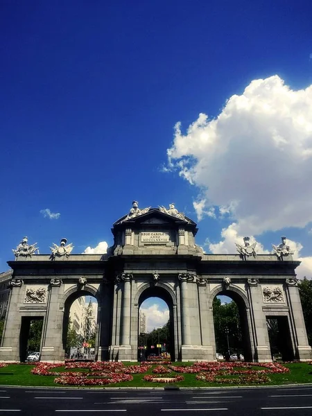 Scatto verticale del monumento neoclassico Puerta de Alcala a Madrid sotto un cielo blu — Foto Stock