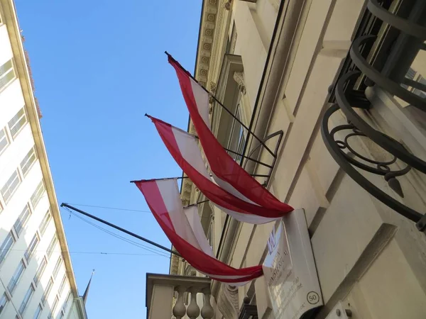 Låg vinkel skott av flera flaggor hängande från en byggnad — Stockfoto