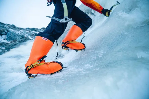 Foto de cierre de una bota de escalada de hielo anaranjado con grampones adjuntos. — Foto de Stock