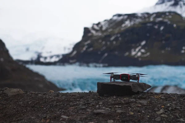 Drönare på en klippa med kullarna och glaciären på suddig bakgrund på Island — Stockfoto