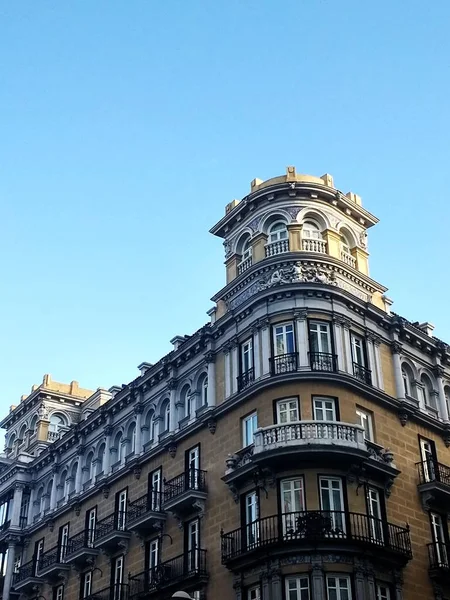 Niski kąt ujęcia budynku w Madrycie pod jasnym niebieskim niebem — Zdjęcie stockowe