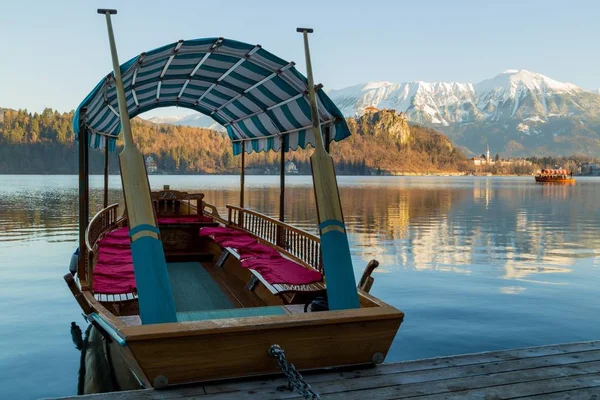 Красива картина дерев'яного човна на озері з лісом і горами на задньому плані — стокове фото