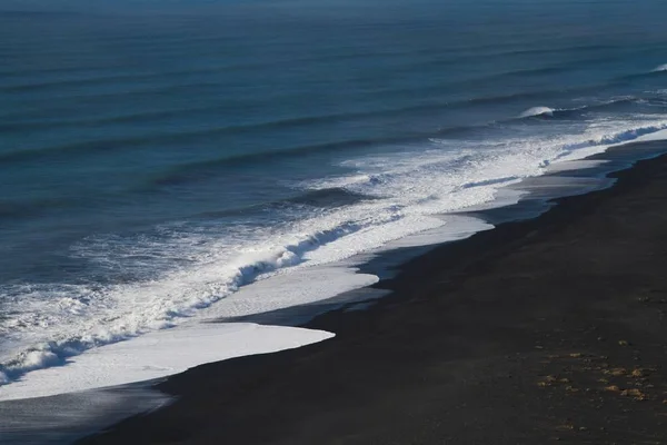 Spiaggia circondata dal mare sotto la luce del sole in Islanda — Foto Stock
