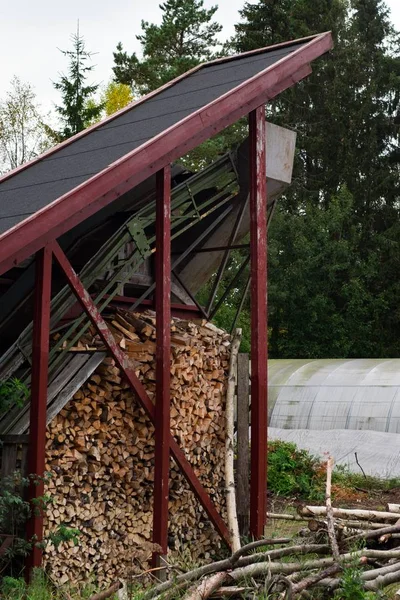 Verticaal schot van een gestapeld gehakt hout onder een oude sorteermachine in Noorwegen — Stockfoto