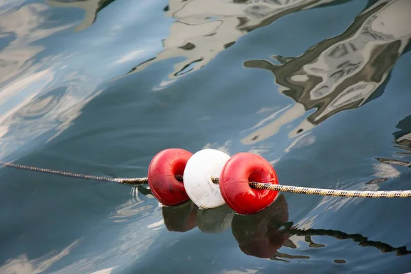 Közelkép piros-fehér körökről egy kötélen a vízben. — Stock Fotó