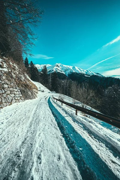 Tiro Vertical Caminho Neve Lado Uma Montanha Com Montanhas Cobertas — Fotografia de Stock