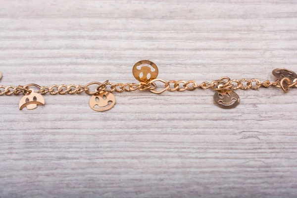 Closeup shot of a rusty golden bracelet with smiling emojis — Stock Photo, Image