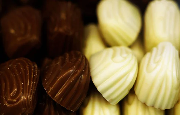 Sötét Fehér Csokis Cukorkák Közelsége Fények Alatt Homályos Háttérrel — Stock Fotó