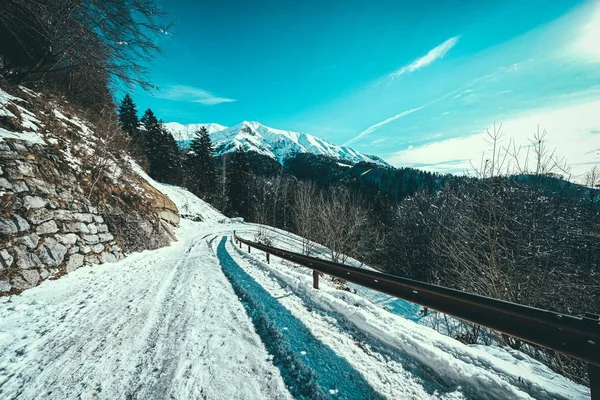 Caminho Neve Lado Uma Montanha Com Montanhas Cobertas Neve Fundo — Fotografia de Stock