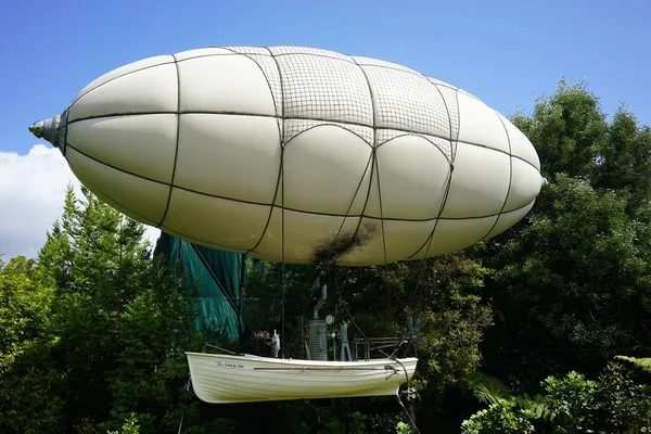 Hermosa toma de un dirigible blanco rodeado de exuberante naturaleza — Foto de Stock