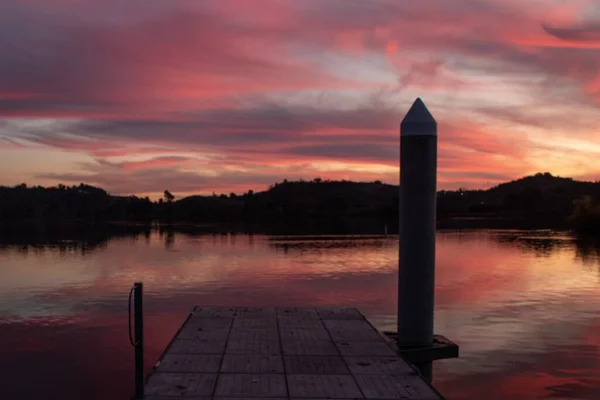 Étang de pierre sur un petit lac devant les collines pendant le coucher du soleil — Photo