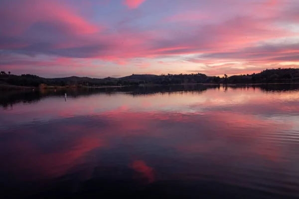 Schöne Aufnahme eines kleinen Sees mit fantastischem dunkelrosa Sonnenuntergang am Horizont — Stockfoto