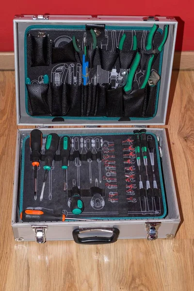 Pelican case full of household tools on a floor under the lights