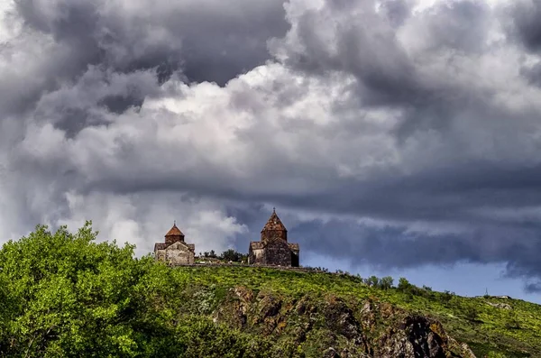 Bred vinkel skott av en kyrka på berget under en molnig himmel — Stockfoto