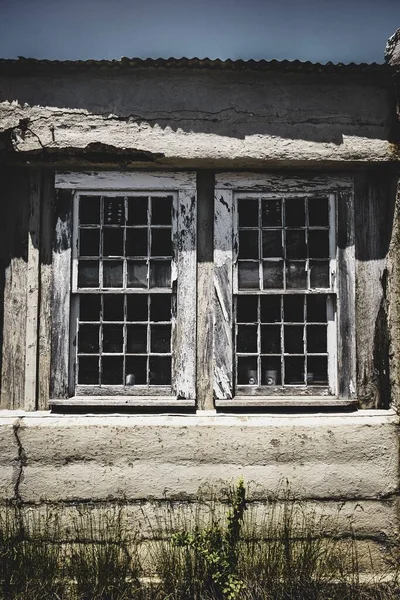 一座有两扇受损窗户的古老乡村建筑的垂直截图 — 图库照片