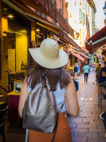 Κάθετη φωτογραφία μιας γυναίκας με καπέλο να περπατάει σε στενά δρομάκια. — Φωτογραφία Αρχείου