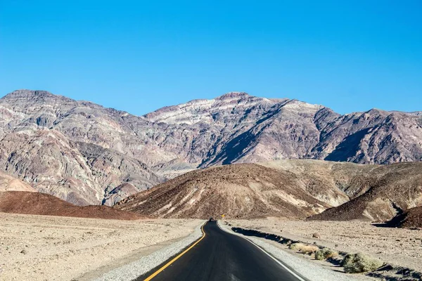 Tiro de uma estrada perto das montanhas maciças em Death Valley National Park, Califórnia EUA — Fotografia de Stock