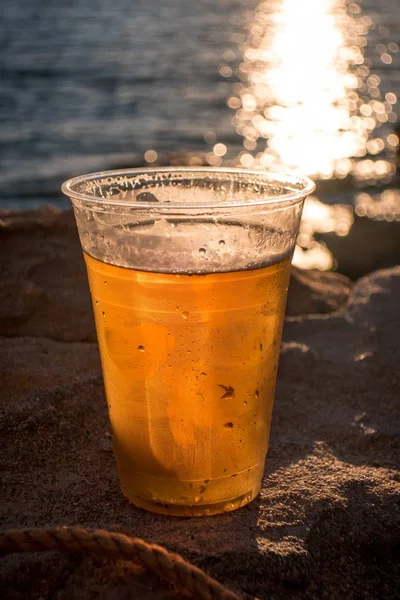 Uma Xícara Cerveja Fundo Oceano Durante Pôr Sol — Fotografia de Stock