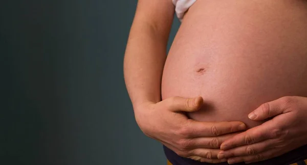 รูปถ่ายใกล้ชิดของผู้หญิงท้องถือท้องของเธอ — ภาพถ่ายสต็อก