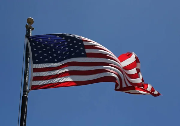 Låg vinkel skott av den amerikanska flaggan under en klarblå himmel — Stockfoto