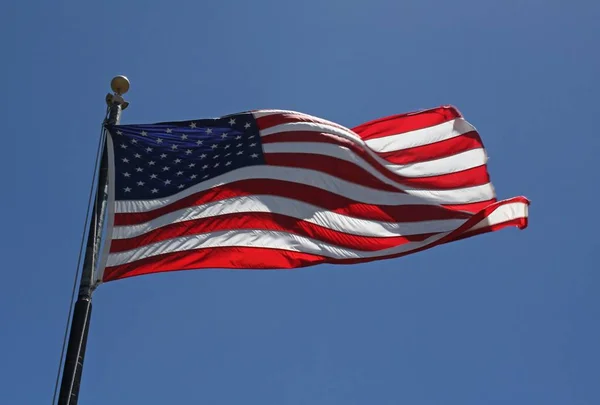 Χαμηλή γωνία βολής της σημαίας των ΗΠΑ κάτω από έναν καταγάλανο ουρανό — Φωτογραφία Αρχείου