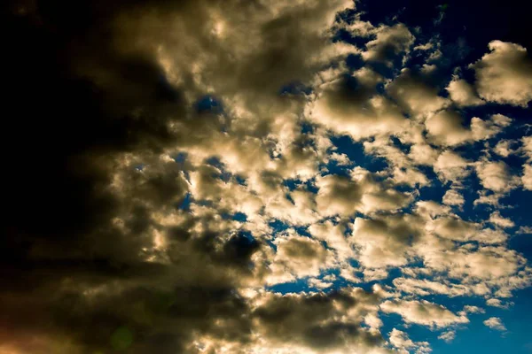 Foto en ángulo bajo de nubes en un cielo azul soleado. —  Fotos de Stock