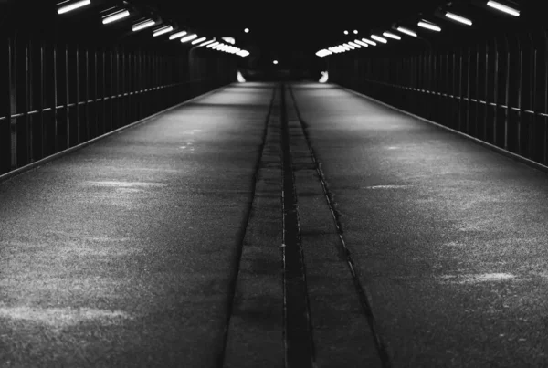 Graustufenaufnahme eines dunklen Tunnels, der zu einem unbekannten Ort führt — Stockfoto