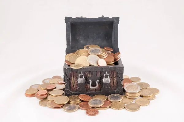 Beautiful shot of a small treasure box full of coins with a white color in the background — Stock Photo, Image