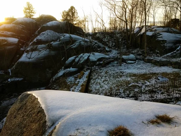 Campo cercado por rochas e árvores cobertas de neve sob a luz do sol em Larvik, na Noruega — Fotografia de Stock