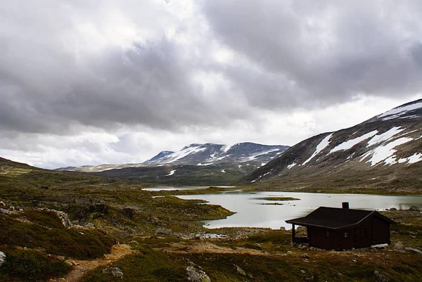 Norveç 'te yüksek kayalık dağları olan güzel bir arazide kır evi. — Stok fotoğraf