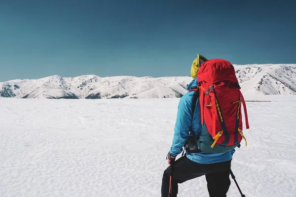 Detrás de la foto de un hombre mirando la impresionante vista de las nevadas montañas Cárpatos en Rumania — Foto de Stock