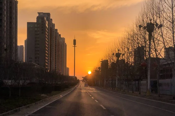 Εκπληκτική φωτογραφία ενός ηλιοβασιλέματος κατά μήκος του δρόμου στη μέση μιας σύγχρονης πόλης — Φωτογραφία Αρχείου