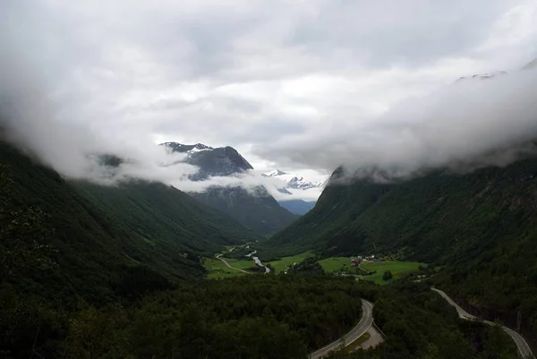 Prachtig landschap van een groen landschap van bergen omhuld door mist — Stockfoto