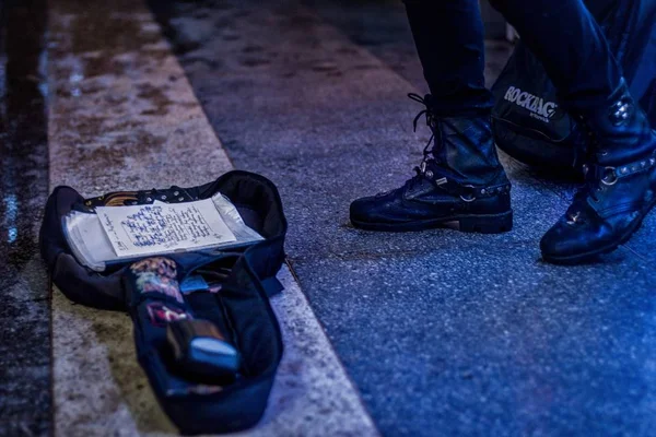 Foto de bajo ángulo de la bolsa de guitarra delante de los zapatos de alguien. —  Fotos de Stock