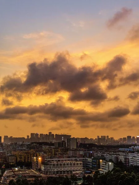 Ευρεία βολή μιας σύγχρονης και πολυάσχολης πόλης με λαμπερό ουρανό και σύννεφα κατά τη διάρκεια του ηλιοβασιλέματος — Φωτογραφία Αρχείου