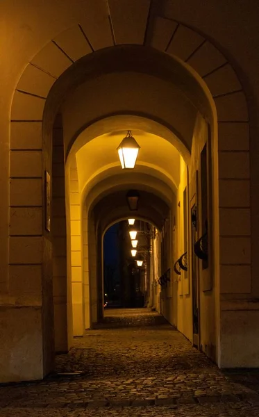 Vue nocturne de la rue avec des arcs dans les bâtiments sous des lumières artificielles — Photo