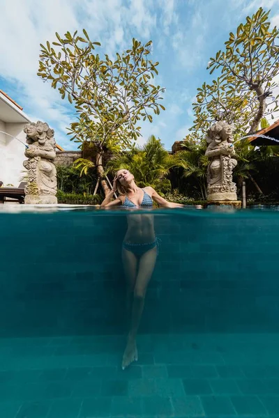 Mujer con traje de baño nadando en el agua de la piscina durante el día. — Foto de Stock