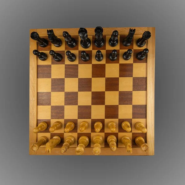 Overhead shot of a black and brown classic chessboard on a dark surface — Stock Photo, Image