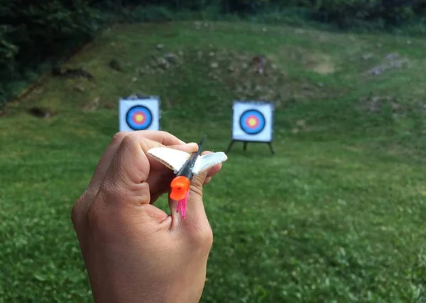 Primo piano colpo di una persona con una freccia che si prepara a lanciare — Foto Stock