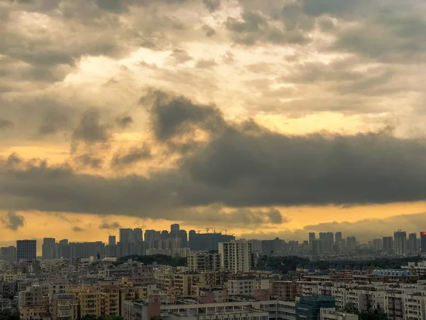 Vista para uma cidade moderna e movimentada com nuvens cinzentas durante o pôr-do-sol — Fotografia de Stock
