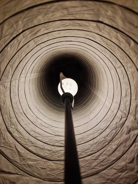 À l'intérieur d'un abat-jour avec une ampoule blanche allumée dans une pièce sombre — Photo