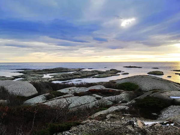Norveç 'teki Rakke' de gün batımında bulutlu bir gökyüzünün altındaki kayalarla çevrili deniz. — Stok fotoğraf